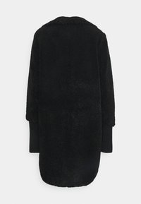 Czarny polarowy płaszcz o miękkiej fakturze, z kołnierzem oraz długimi rękawami. Żebrowane mankiety na końcach rękawów poprawiają dopasowanie.