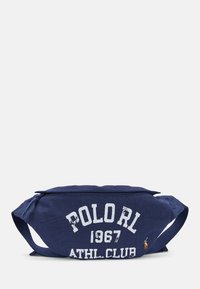 Marin canvas midjeväska med vit slitna texten: "POLOrl 1967 ATHL. CLUB." Har två remmar och en liten logotypaccent på ena sidan.