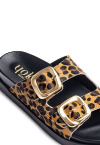 Zapato de slide con estampado de leopardo que presenta dos hebillas doradas, plantilla texturizada negra y una suela negra resistente.