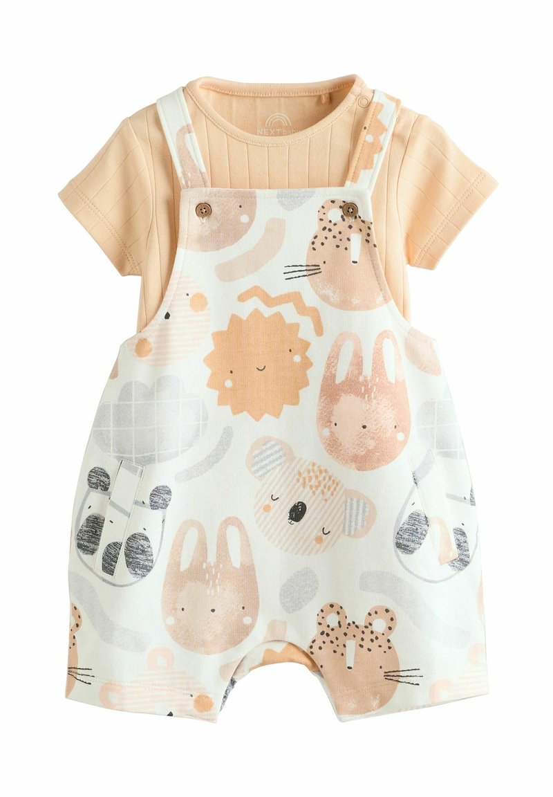Chemise à manches courtes de couleur pêche associée à des salopettes blanches ornées de motifs animaliers dans des teintes pastel douces et dotées de boutons en bois.