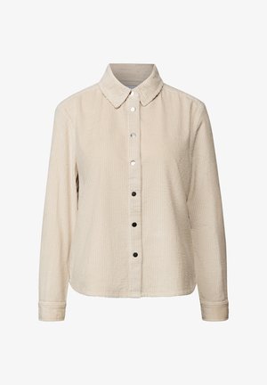 Beige corduroy long-sleeve shirt with a pointed collar and black and white snap buttons down the front.
