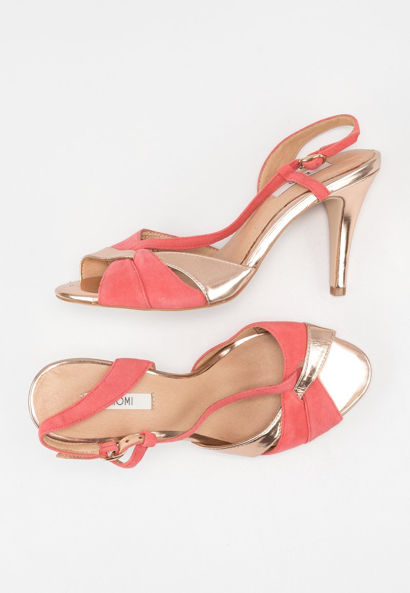 Koraleowe zamszowe sandały na obcasie z metalicznym złotym akcentem i otwartym noskiem. Posiadają smukły pasek wokół kostki oraz krzyżujące się przody.