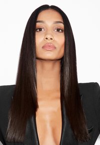 Lang, steil zwart haar met een gladde textuur; draagt een diep V-hals zwart blazer. Huidtoon is medium met natuurlijke make-up.