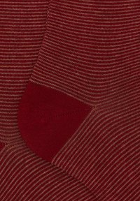 Calze a righe rosse e beige con una texture a costine, con punta e tallone rossi solidi. Le righe sono equidistanti lungo tutta la calza.