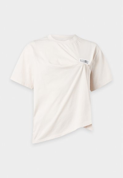 T-shirt σε εκρού χρώμα με κοντά μανίκια, στριφογυρισμένη λεπτομέρεια στην μπροστινή πλευρά και μικρή ορθογώνια ετικέτα κοντά στον αριστερό ώμο.