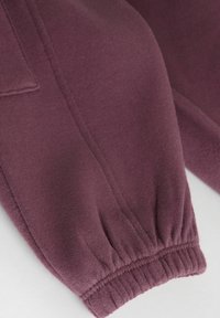 Sweatshirt en mélange de coton violet avec des manches à poignet côtelé, arborant une texture lisse et des détails de couture soignés.