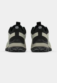 Grå og svarte turstøvler med teksturerte gummisåler, polstrede krager og en løfteløkke bak. Minimalistisk design med diskrete turkise detaljer.