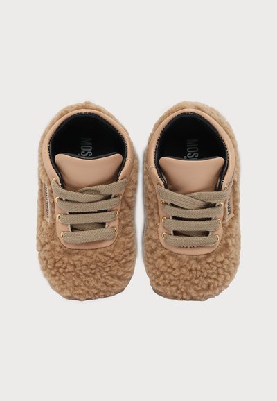 Двойка кафяви обувки за деца с мека, текстурирана материя, бежови връзки и подплатен език, показани отгоре на бял фон.