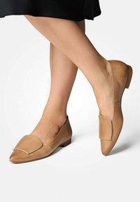 Tan leren platte schoenen met een spitse neus en een decoratieve klepaccent, voorzien van een laag hakje en een gladde textuur.