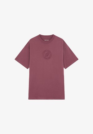 T-shirt en coton bordeaux avec un col rond et des manches courtes. Présente un design de logo texturé sur la poitrine, style minimaliste et décontracté.