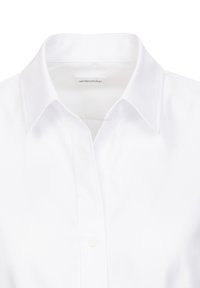 Witte, langwerpige shirt met een puntige kraag, gemaakt van soepele stof, met een knoopsluiting aan de voorkant en een merklabel aan de binnenkant van de kraag.