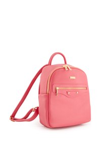 Sac à dos en cuir rose avec une forme arrondie, quincaillerie dorée, une poignée supérieure et une poche avant zippée. Détail de surface texturé visible.