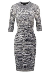 Strickkleid mit tailliertem Schnitt, ausgestattet mit einem strukturierten Muster in Schwarz und Creme, mit drei Viertelärmel und hohem Ausschnitt.