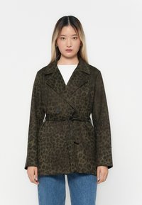 Leopardmönstrad kappa i mörk olivgrön. Har en dubbelknäppt design, breda slag, knytmidja och mjuk textur. Kombinationen är med denim.