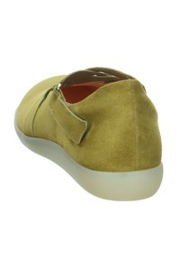Green suede slip-on shoes with a rounded toe, featuring a Velcro strap, soft inner lining, and a translucent rubber sole.