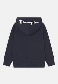 Marinblå hoodie med långa ärmar, ribbade muddar och "Champion"-text i vitt på baksidan av huvan.