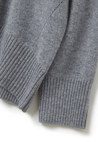 Grauer Pullover mit weicher Textur, featuring gerippte Bündchen und Saum. Der Stoff wirkt warm und ist leicht fusselig, mit einem regulären Schnitt.