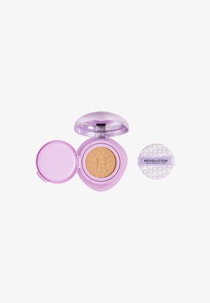 Fond de teint compact violet avec applicateur éponge beige arborant la marque « Revolution » sur fond blanc.