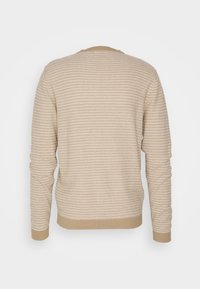 Beige randig tröja med långa ärmar, rund halsringning, ribbad mudd och nederkant. Mjuk textur med växlande ljusa och mörka ränder.