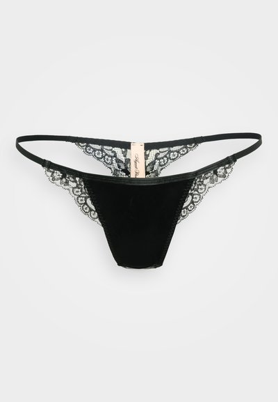 String noir en dentelle avec un devant en velours doux et des côtés en dentelle transparente, doté d'une taille étroite et d'une étiquette au dos.