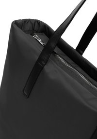 Mustat kassi virtaviivaisella designilla, jossa on kiiltävä pinta, nahkahandlet ja vetoketjullinen yläosa. Minimalistinen ja toiminnallinen.