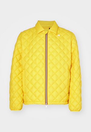 Yellow quilted jacket with a zip closure, featuring a collar and contrasting striped detail along the zipper. Lightweight, padded design.