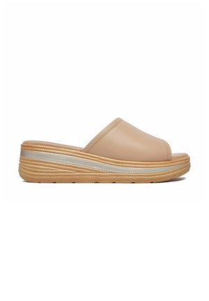 Beżowa sandałka typu slip-on z odkrytymi palcami, z grubą teksturowaną podeszwą i srebrnym paskiem z boku, widoczna w widoku z profilu.