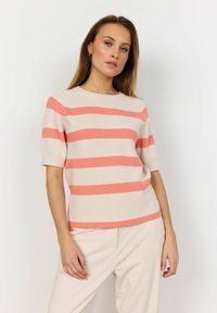 Striped short-sleeve sweater in beige and coral, featuring a ribbed texture and a crew neckline. Paired with cream-colored trousers.