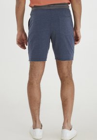 Mörkblå bomullsshorts med en grå elastisk midja, med sidofickor och en bakficka, avslutade med en rå fåll.
