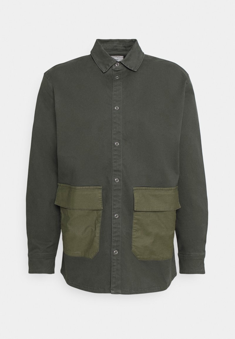 Dark green shirt jacket made of cotton with two large front pockets in a contrasting lighter green. Features a collared neckline and button closure.