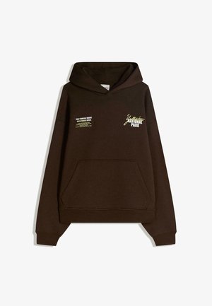 Felpa con cappuccio marrone e tasca frontale, con grafiche testuali bianche e gialle che dicono "Parco Nazionale Yellowstone" e una citazione.
