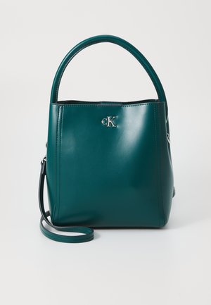 Teal leather handbag featuring a structured design, rounded handles, and a detachable shoulder strap. Silver logo accent on front.