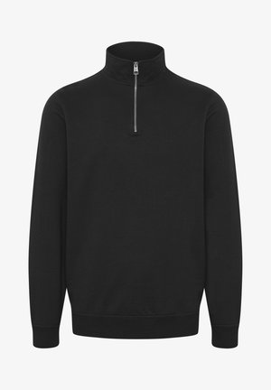 Pull noir à col zippé fabriqué dans un tissu doux et extensible. Il dispose d'un col haut, de manches longues et de poignets et d'un bas côtelés pour un ajustement confortable.