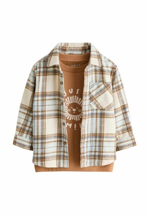 Barnets brune t-shirt med print af et smilende løve under en åben beige og blå ternet skjorte med brystlomme.