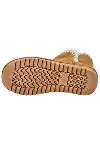 Tan nubuck bootsoled med en struktureret gummiydersål, der har et bølget mønster og et logoaftryk. Shearling-pynt langs den øverste kant.