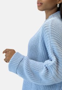 Jersey de punto azul claro con un patrón texturizado, con mangas acanaladas y un escote redondo. Incluye un ajuste holgado y relajado.