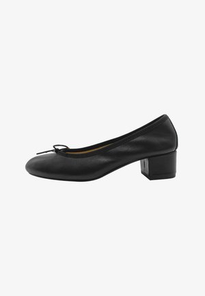 Zapato de tacón de cuero negro con punta redonda, pequeño detalle de lazo en la parte delantera y tacón cuadrado. Textura suave con acentos de diseño mínimos.