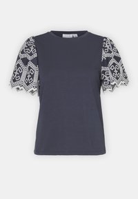 Mörkblå kortärmad topp med vitt spetsblommönster på ärmarna och flikiga kanter, rund halsringning och rak nederkant.