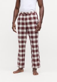 Pantalones de salón a rayas en rojo, blanco y gris de algodón. Cintura elástica con cordón, piernas rectas y un bolsillo lateral con etiqueta.