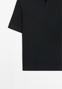 Schwarzes, geripptes Strickshirt mit kurzen Ärmeln, einem dezenten V-Ausschnitt und gekrempelten Ärmeln, dargestellt vor weißem Hintergrund.