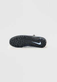 Zapato deportivo negro con suela de goma moldeada, patrones de agarre texturizados y un acento del logo de Nike en azul claro. Parte superior sintética ligera.