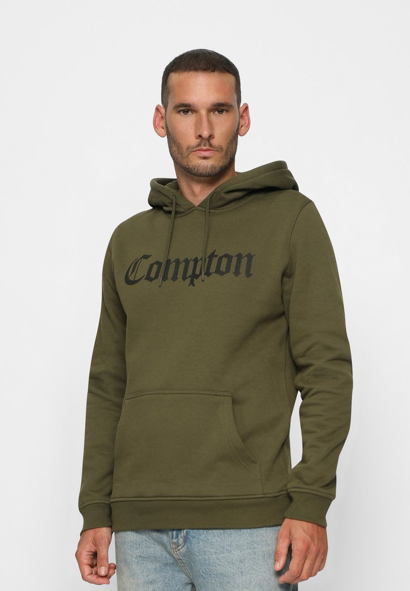 Sudadera color verde oliva con bolsillo frontal tipo canguro, capucha con cordón y el texto en negrita "Compton" en el pecho. Material de mezcla de algodón.