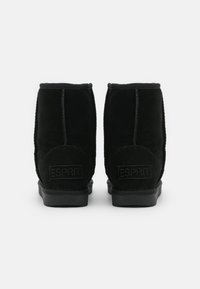 Para czarnych zamszowych botków za kostkę z płaską podeszwą, widocznymi szwami i wytłoczonym logo ESPRIT z tyłu obcasa.