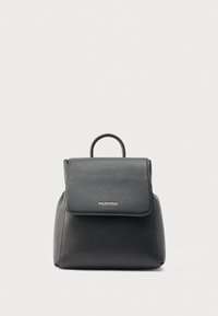 Mochila de cuero negro con un acabado texturizado, un asa superior y una solapa con cierre que presenta letras doradas. Forma compacta con bordes redondeados.