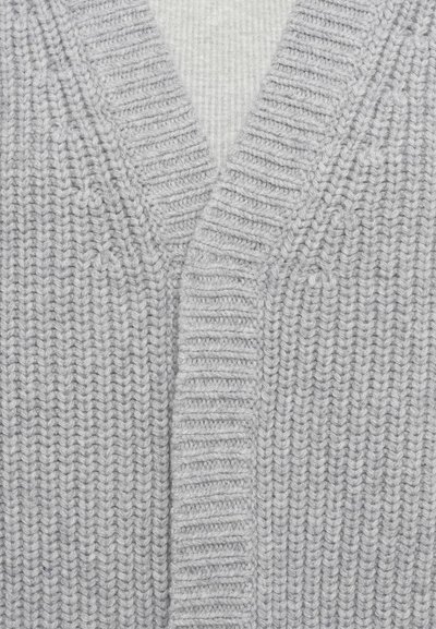Heled hall villase sweater, millel on V-kaelus. Omab soonikkoesid ja vertikaalseid jooni, mis rõhutavad üldstruktuuri ja välimust.