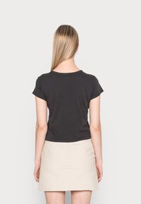 Svart kortärmad åtsittande t-shirt med rund halsringning, visad från baksidan. Tyget ser slätt ut med en enkel design och inga synliga mönster.