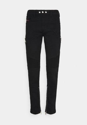 Pantaloni neri slim fit con pannelli a costine sulle ginocchia, vita con doppio bottone, tasche frontali e laterali con zip, e cerniere alla caviglia su sfondo bianco.