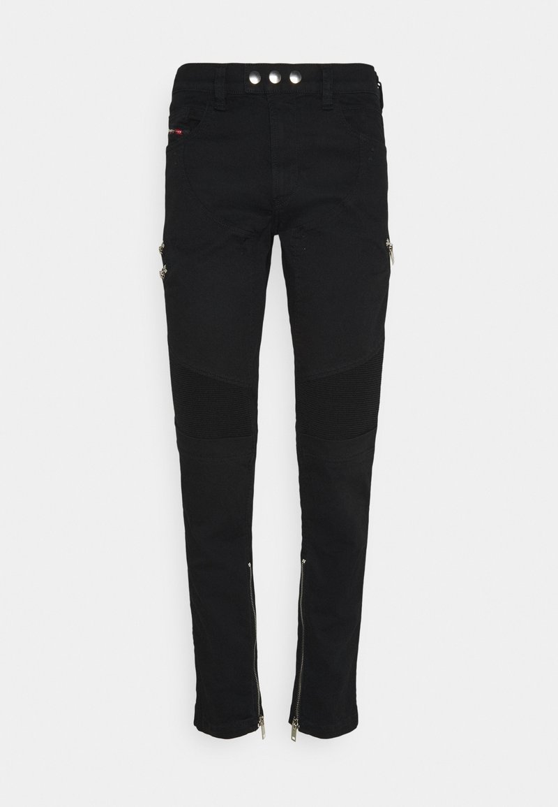 Pantalon noir ajusté avec panneaux côtelés aux genoux, taille à double bouton, poches avant et latérales zippées, et fermetures éclair aux chevilles sur un fond blanc.