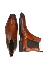 Botas Chelsea de cuero marrón con acabado texturizado, perforaciones decorativas, paneles laterales elásticos y un tacón bajo.