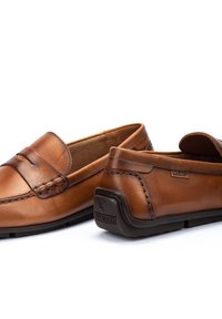 Braune Lederloafers mit einer gesteppten Design, mit einer gerundeten Spitze und einem gepolsterten Innenraum. Die Hardware umfasst ein Logo-Detail an der Ferse.